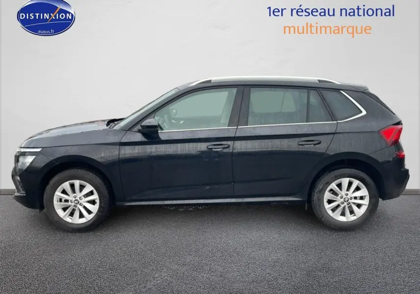 Vue latérale droite d'un Skoda Kamiq noir 2025 avec jantes alu et barres de toit visibles.