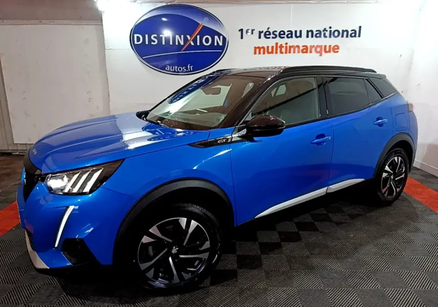Peugeot 2008 BlueHDi 130 GT bleu en 3/4 avant droit, toit noir et jantes alliage distinctives.