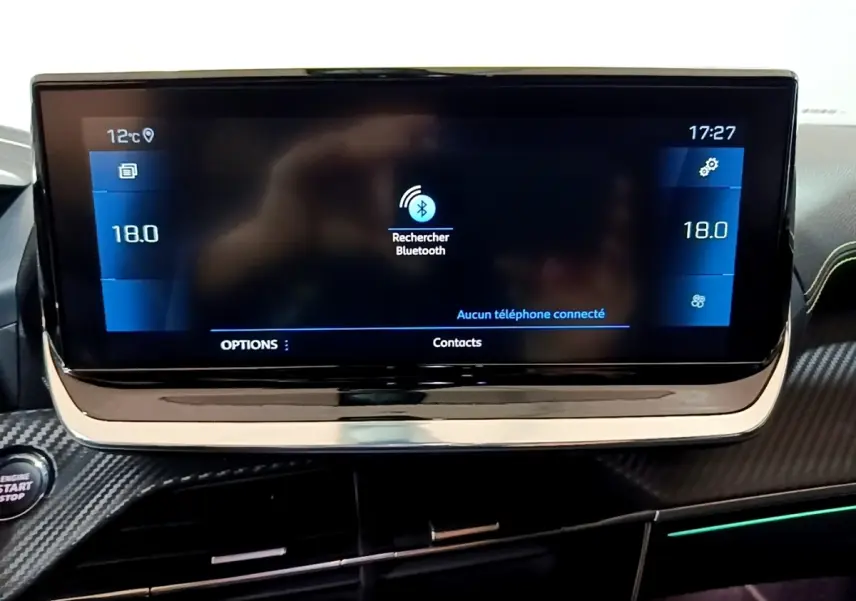 Écran tactile central du tableau de bord du Peugeot 2008 GT bleu, affichant la recherche Bluetooth et la température à 18°C.