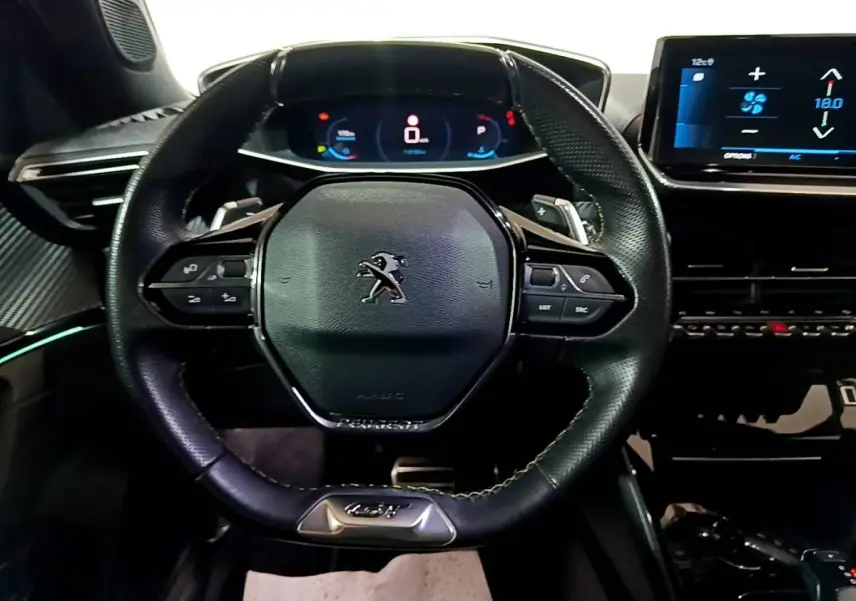 Vue rapprochée du volant cuir noir multifonctions et du tableau de bord numérique du Peugeot 2008 GT 2021.