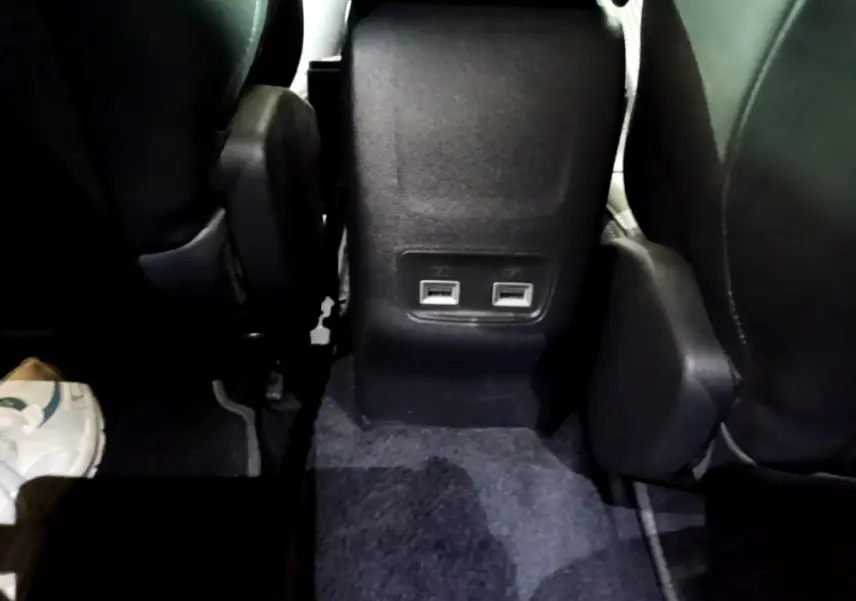 Vue rapprochée des ports USB arrière entre les sièges noirs du Peugeot 2008 Bleu Diesel, version GT 2021.