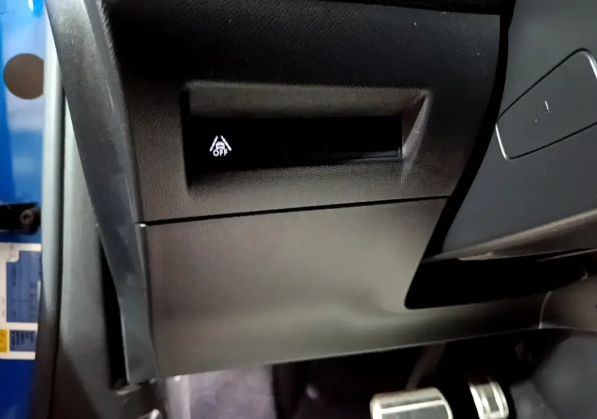 Détail intérieur côté gauche du tableau de bord du Peugeot 2008 Bleu avec bouton d’activation d’aide à la conduite.