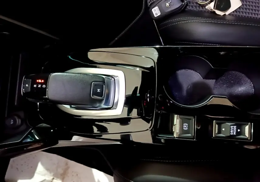 Vue plongeante sur la console centrale noire brillante du Peugeot 2008 GT avec levier de vitesse automatique et commandes Drive Mode.