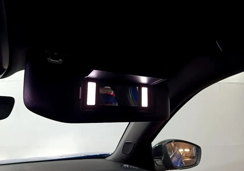 Vue intérieure du pare-soleil avec miroir éclairé côté gauche d’un Peugeot 2008 Bleu version GT 2021.
