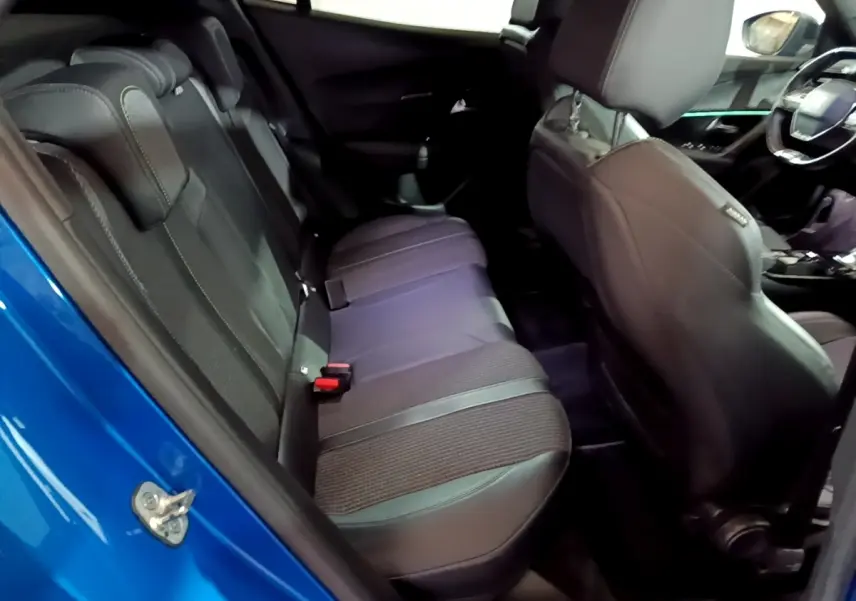 Vue intérieure côté gauche sur la banquette arrière noire et le tableau de bord du Peugeot 2008 bleu 2021.