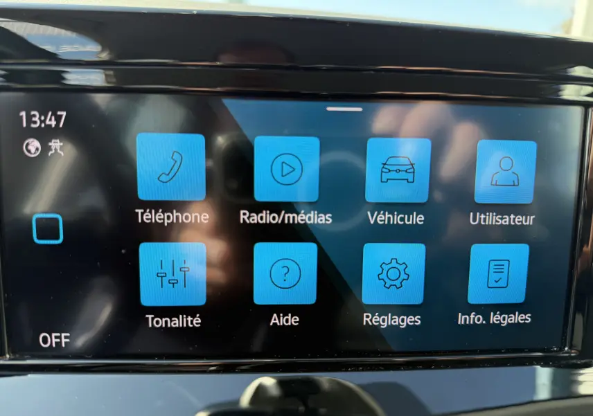 Écran tactile central de la Volkswagen Golf blanche 2020 affichant le menu principal avec icônes bleues.