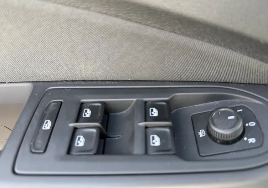 Gros plan sur les commandes des vitres et rétroviseurs côté conducteur d'une Volkswagen Golf blanche 1.0 TSI 110 LIFE 2020.