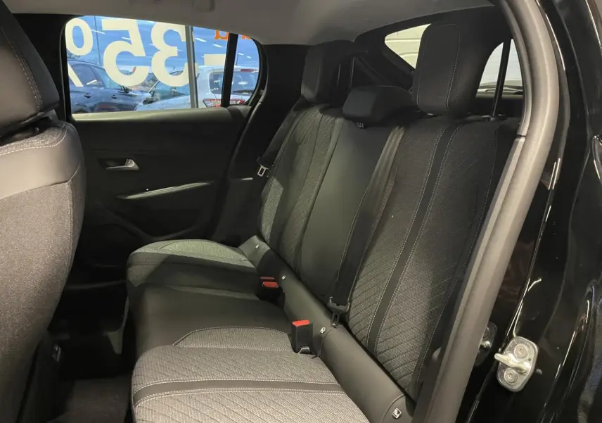 Vue intérieure côté droit sur la banquette arrière tissu et cuir de la Peugeot 208 noire métallisée avec port USB arrière visible.
