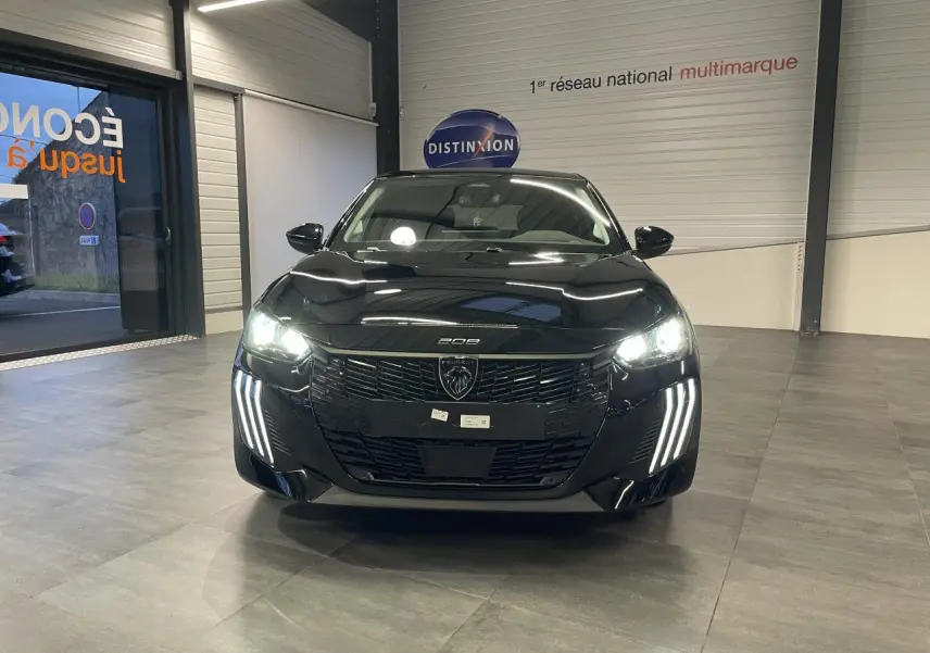 Vue avant d'une Peugeot 208 noire métallisée avec phares allumés et signature lumineuse en griffes LED.