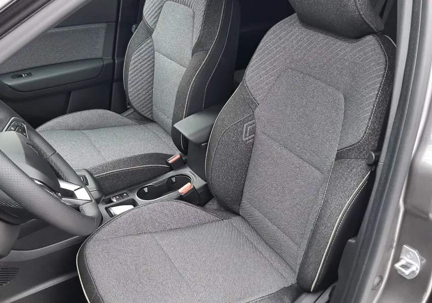 Vue intérieure côté conducteur du Renault Captur E-Tech Full Hybrid 160ch 2026, sièges tissu gris avec surpiqûres claires.