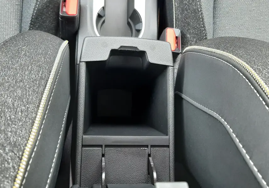 Vue plongeante sur la console centrale ouverte du Renault Captur gris cassiopée avec accoudoirs et porte-gobelets visibles.