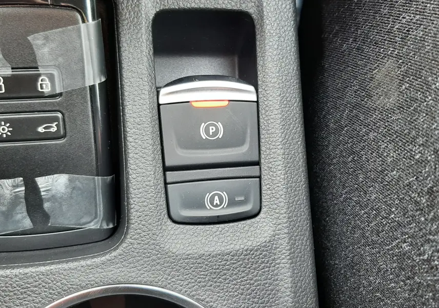 Gros plan sur les commandes de frein à main électronique et arrêt automatique du moteur du Renault Captur E-Tech gris cassiopée.