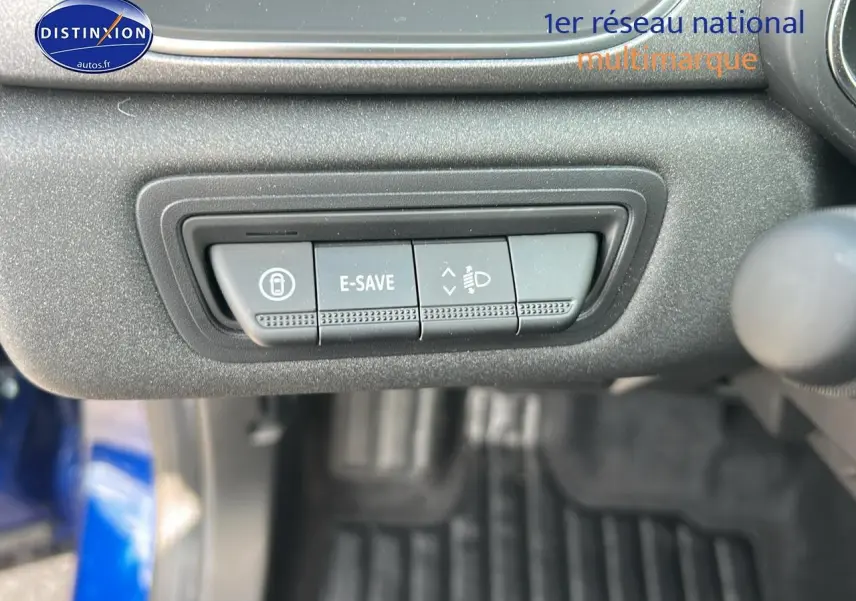 Gros plan sur les commandes E-SAVE et réglage des phares du tableau de bord d’un Renault Captur Bleu Iron.