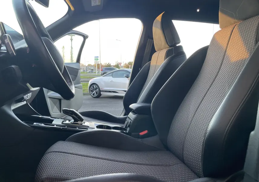 Vue intérieure côté conducteur du DS3 Crossback 2021 noir métal, sièges en cuir noir et tissu gris, levier de boîte automatique visible.
