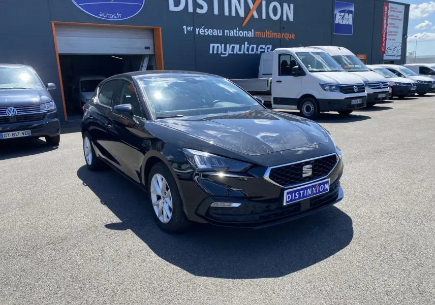 SEAT Leon 2024 noir Midnight vue 3/4 avant droit, avec calandre hexagonale et jantes argentées visibles.