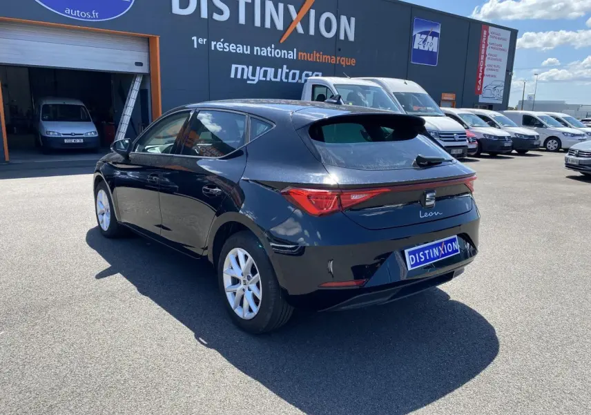 Vue 3/4 arrière droite d'une SEAT Leon 2024 noire Midnight avec vitres surteintées et feux arrière allongés.