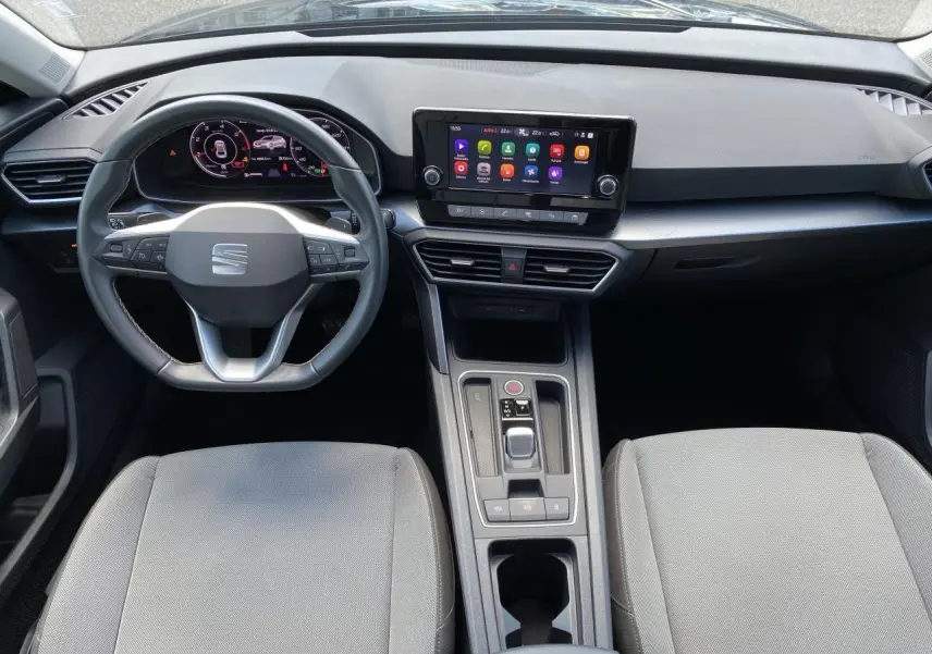 Vue intérieure frontale du poste de conduite du SEAT LEON 2024 avec tableau de bord numérique et écran tactile central.