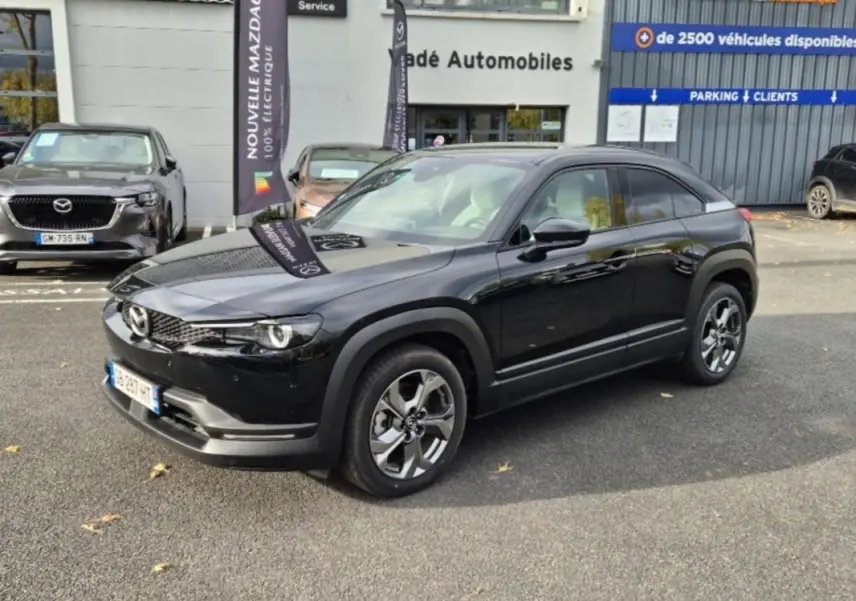 Vue 3/4 avant droite d'un Mazda MX-30 électrique noir, avec jantes alliage et sellerie Modern Confidence visible à travers les vitres.
