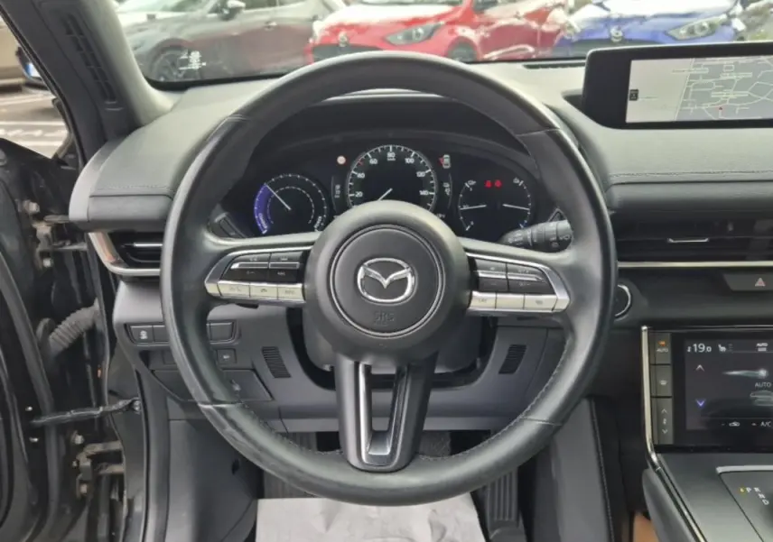 Vue centrée sur le volant noir du Mazda MX-30 électrique 2021 avec tableau de bord et écran tactile visibles.