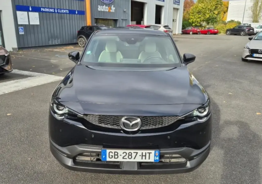 Vue frontale d'une Mazda MX-30 électrique noire 2021 avec intérieur clair et calandre distinctive.