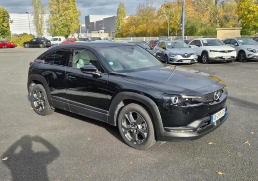 Mazda MX-30 électrique noire vue en 3/4 avant droit, avec ses jantes distinctives et ses lignes épurées modernes.