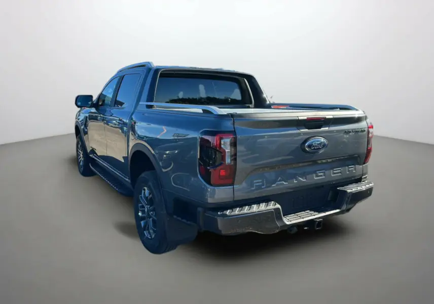 Ford Ranger gris carbone vu de l'arrière côté gauche, avec arceau sport et barres de toit visibles.