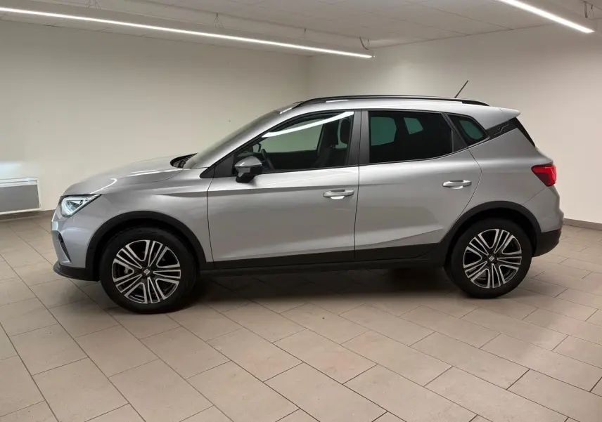 SEAT Arona 2024 gris urbain en vue profil côté gauche, avec vitres arrière surteintées et jantes alliage.