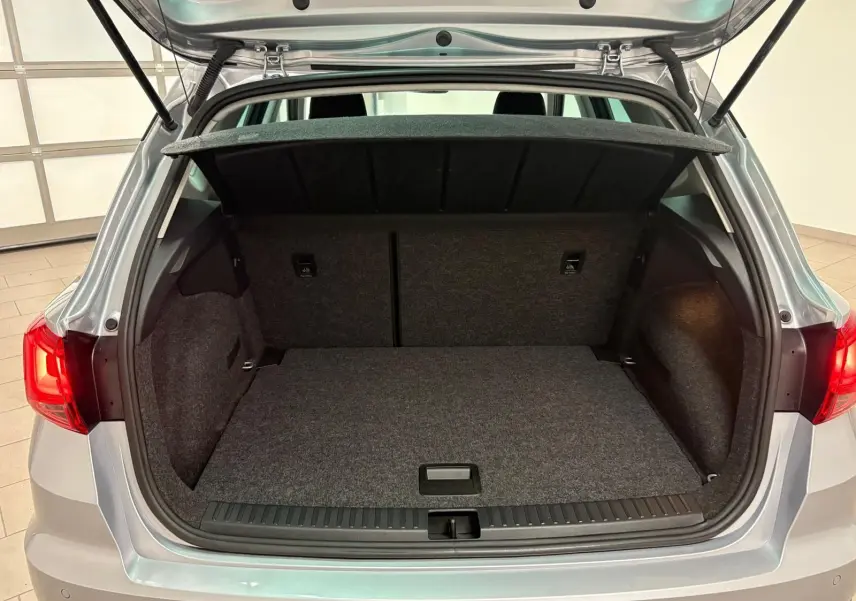 Coffre ouvert vu de l'arrière d'un SEAT Arona 2024 gris urbain avec vitres surteintées arrière.