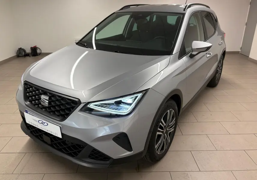 SEAT Arona 2024 gris urbain en 3/4 avant droit avec phares LED et vitres arrière surteintées.