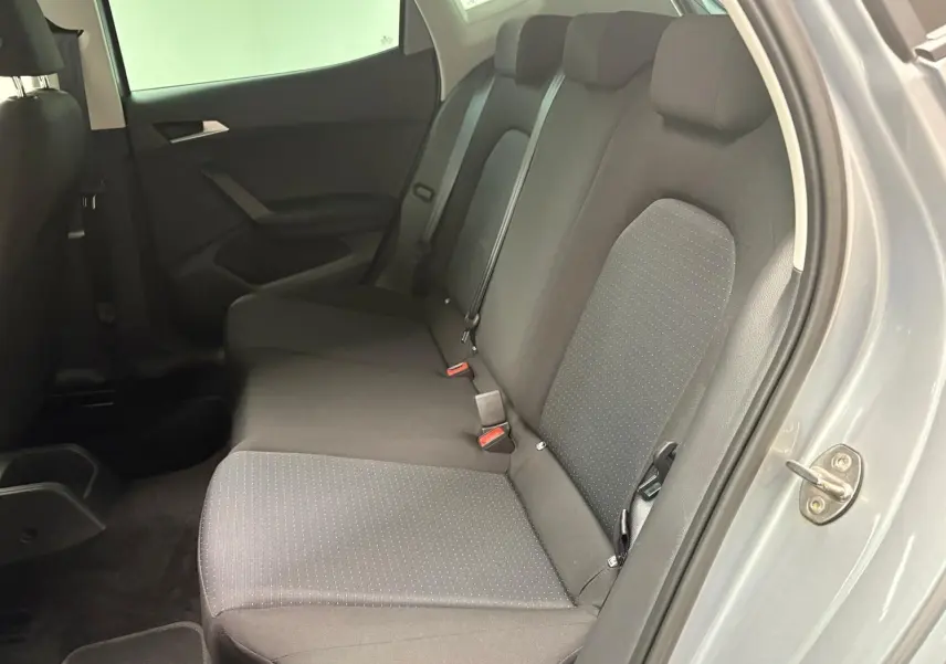 Vue latérale des sièges arrière en tissu gris foncé du SEAT Arona 2024 avec portière ouverte côté droit.