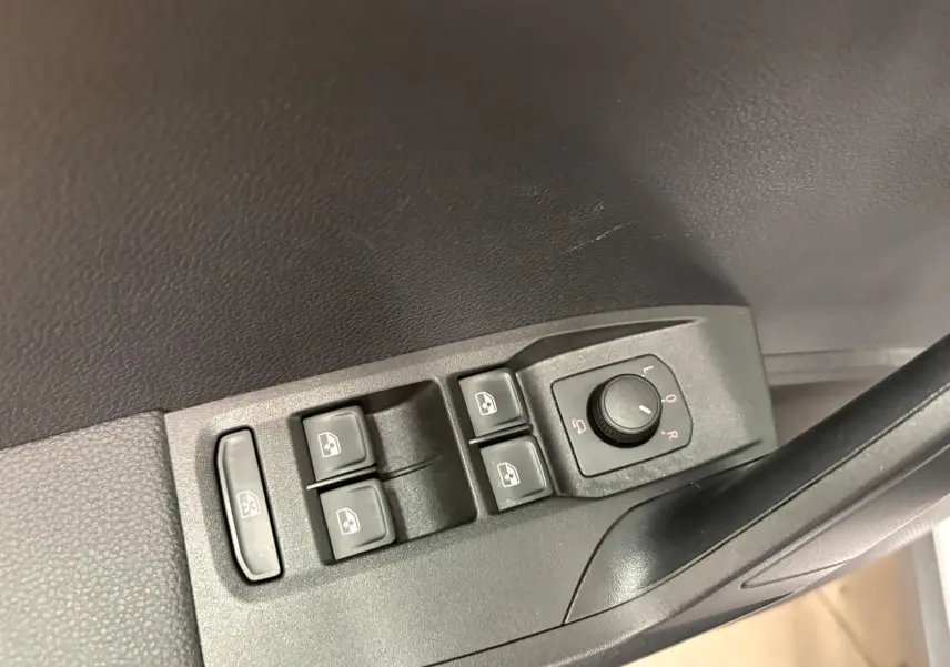 Commandes des vitres électriques et réglage des rétroviseurs côté conducteur du SEAT ARONA 2024 en plastique noir.