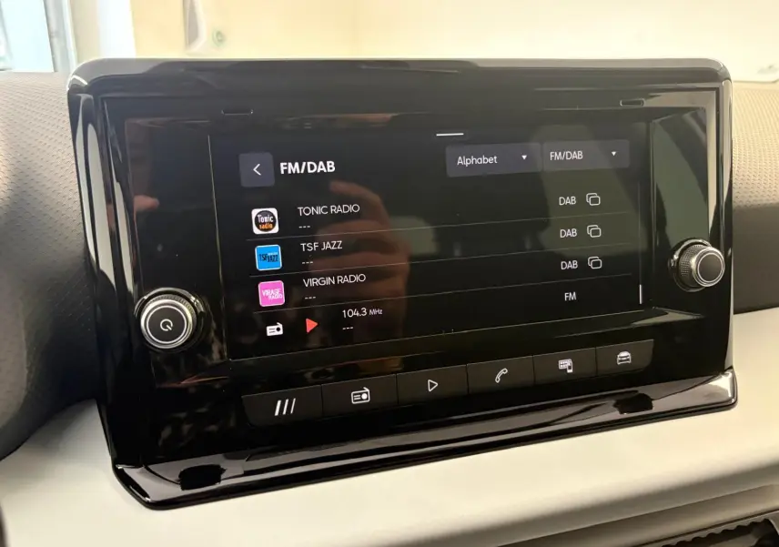 Écran tactile central du SEAT Arona 2024 affichant les stations FM/DAB avec finition intérieure sobre et moderne.