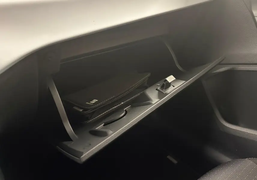 Gros plan sur la boîte à gants ouverte du SEAT Arona 2024, avec un étui noir marqué SEAT à l'intérieur.