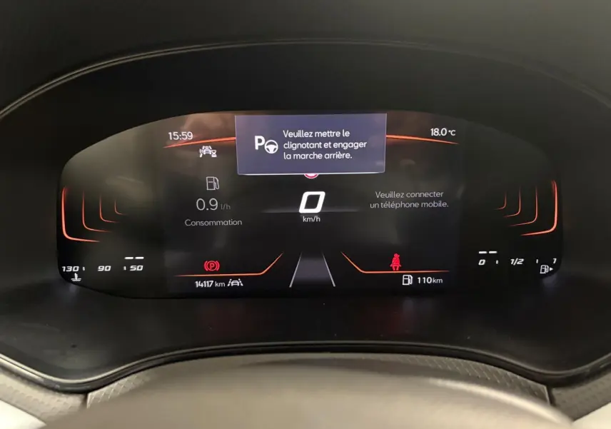 Tableau de bord numérique du SEAT Arona 2024 affichant la consommation, la vitesse à 0 km/h et un message d'alerte.