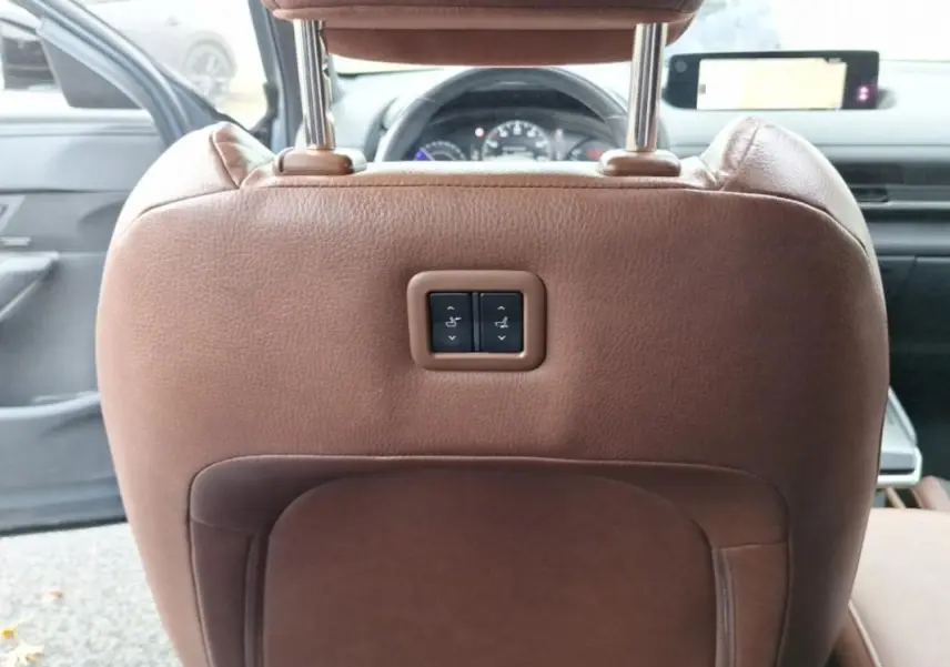 Vue intérieure arrière du siège conducteur en cuir marron avec commandes électriques, tableau de bord et volant visibles dans une Mazda MX-30 gris 2021.