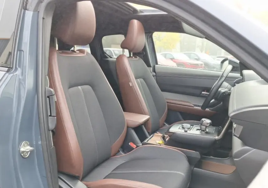 Vue intérieure côté conducteur du Mazda MX-30 gris 2021, sièges bi-matière marron et noir avec console centrale moderne.