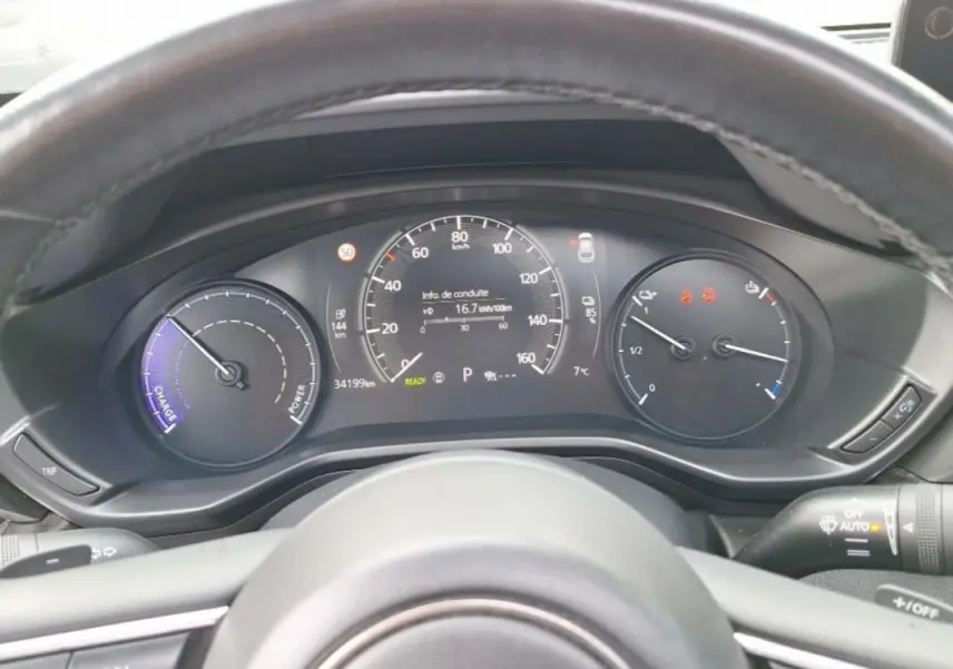 Vue rapprochée du tableau de bord gris du Mazda MX-30 électrique 2021, affichant la vitesse, autonomie et température.