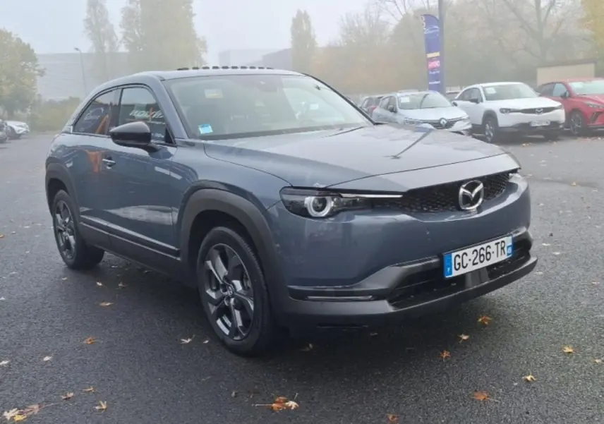 Vue 3/4 avant d'un Mazda MX-30 gris électrique 2021 avec calandre noire et jantes spécifiques version Industrial Vintage.