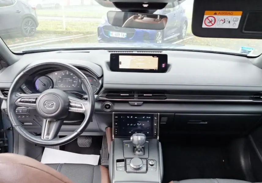 Vue intérieure avant du Mazda MX-30 gris 2021, avec tableau de bord moderne et écran tactile central.