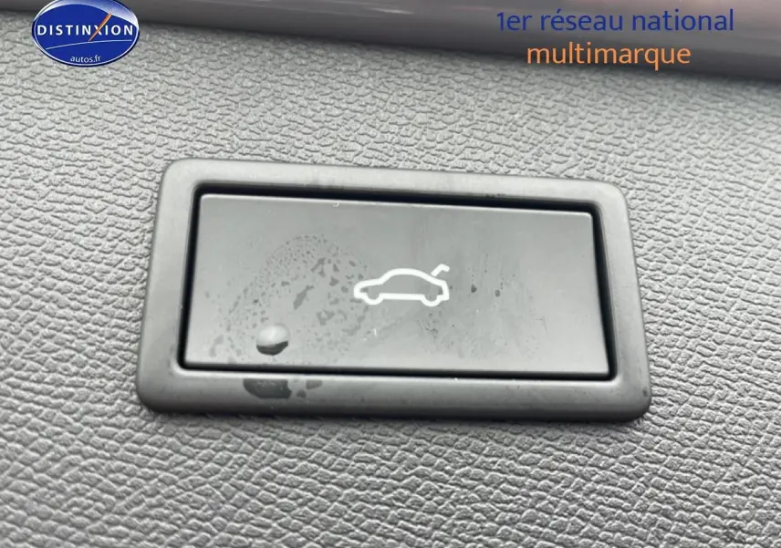 Bouton d'ouverture du coffre sur tableau de bord en plastique noir texturé d'une CUPRA Formentor gris graphene.