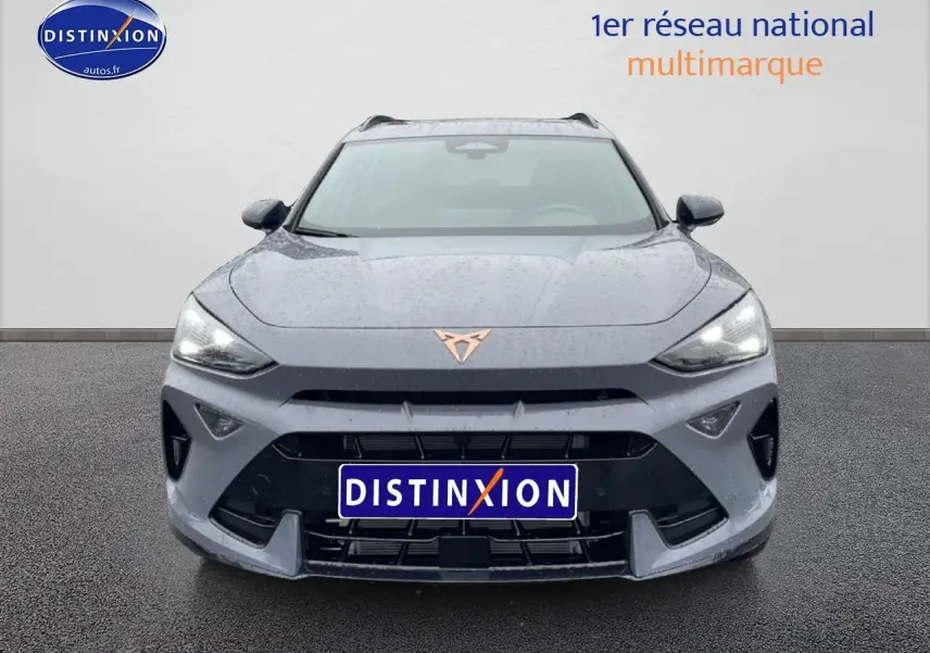 Vue avant d'une CUPRA Formentor gris graphene avec logo cuivré et calandre noire sous la pluie.