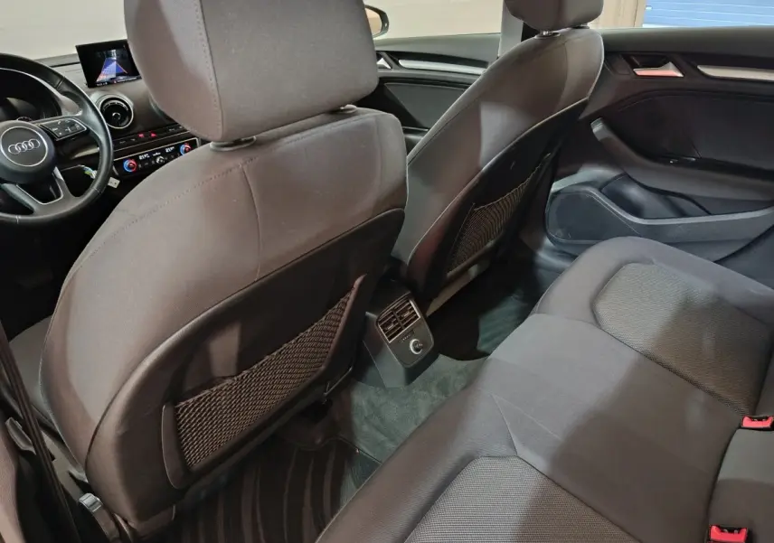 Vue intérieure arrière de l'Audi A3 35 TDI 2020, sièges tissu gris foncé avec aérateurs centraux et tableau de bord visible.