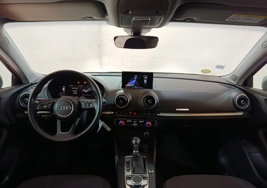 Vue intérieure frontale de l'Audi A3 35 TDI 2020 avec tableau de bord noir et écran central affichant l'aide au stationnement.