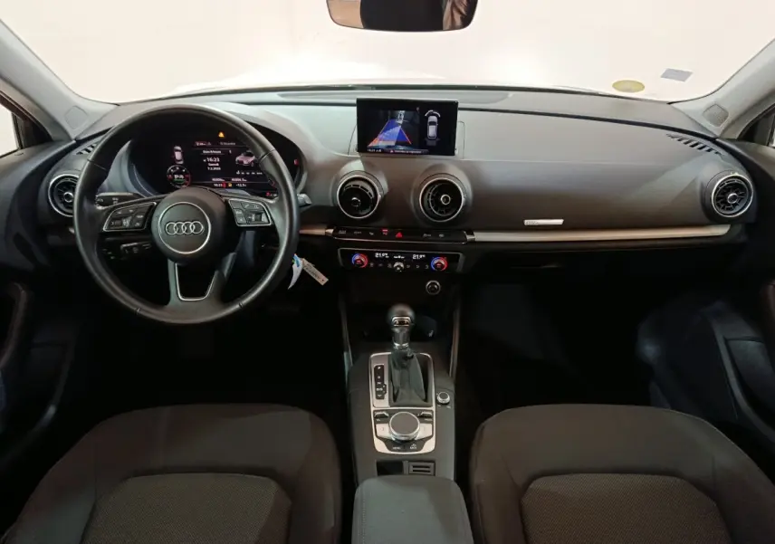 Vue intérieure de face de l'Audi A3 35 TDI Business Line 2020, tableau de bord gris avec écran central et volant cuir noir.