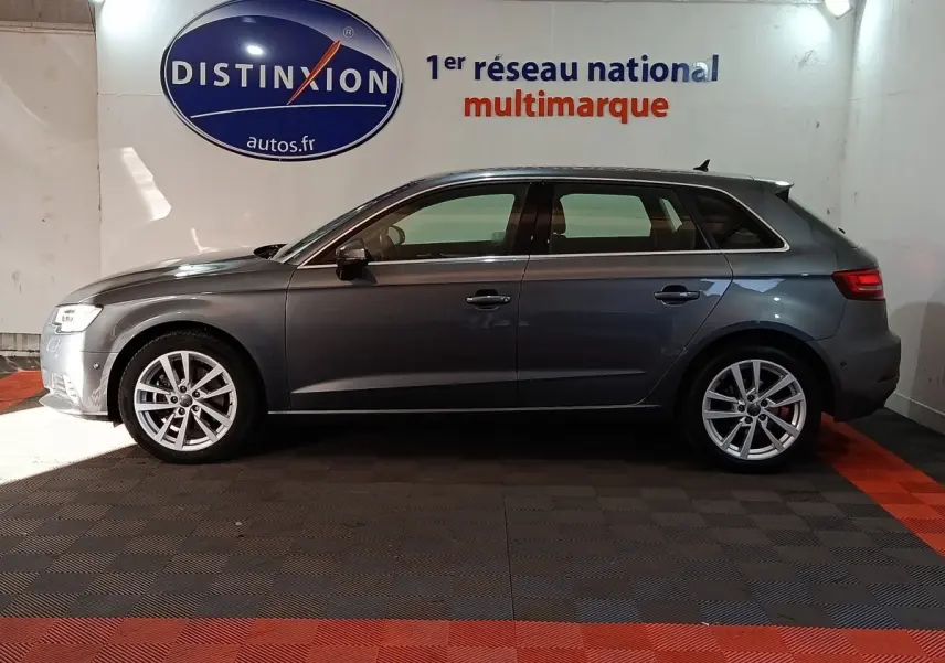 Profil latéral droit d'une Audi A3 gris foncé 2020, avec jantes alliage et feux arrière LED visibles, en intérieur showroom.