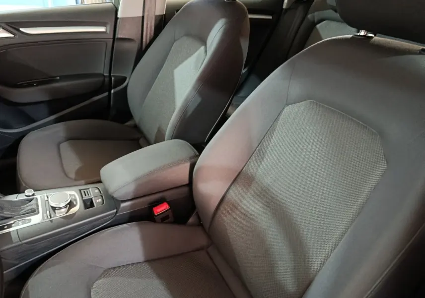 Vue intérieure rapprochée des sièges avant gris foncé et de la console centrale d'une Audi A3 35 TDI 2020.