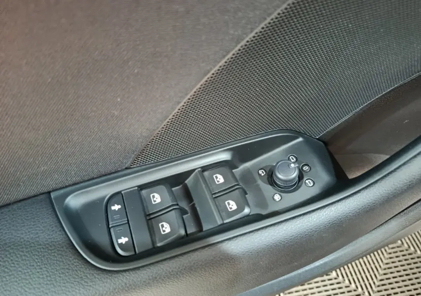 Gros plan sur les commandes des vitres et rétroviseurs côté conducteur d'une Audi A3 gris foncé, version 35 TDI 150 S Tronic Business Line.