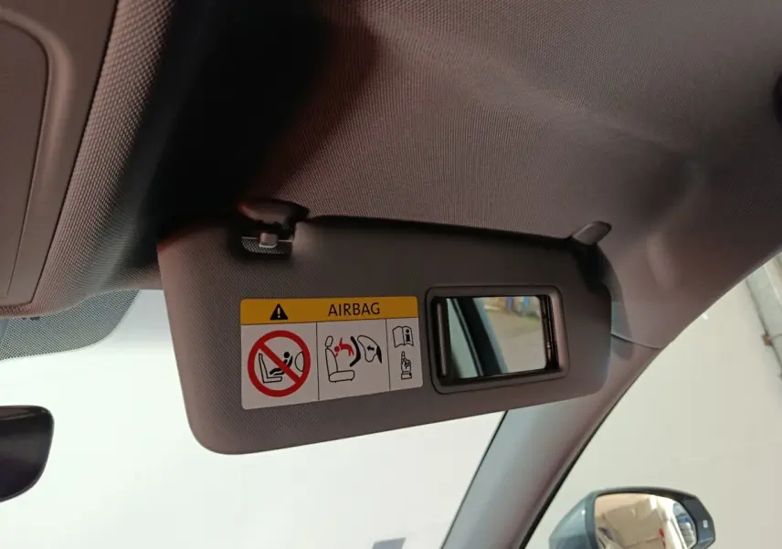 Détail du pare-soleil côté conducteur avec miroir et avertissement airbag dans l'Audi A3 gris foncé 2020.