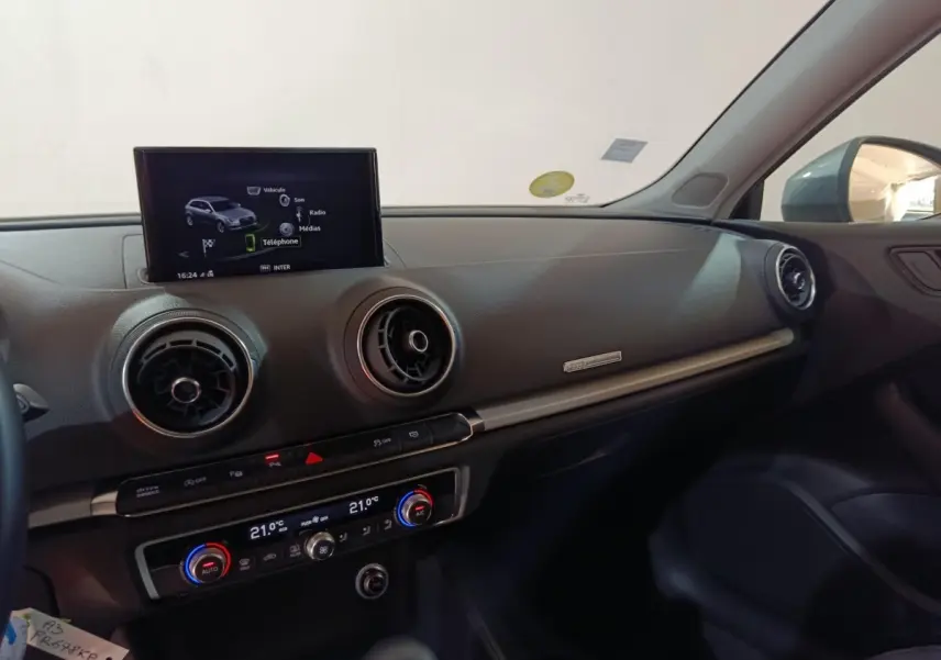 Vue intérieure côté passager de l'Audi A3 35 TDI 2020, tableau de bord noir avec écran multimédia central allumé.