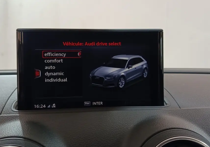 Écran central montrant une Audi A3 gris foncé en vue 3/4 avant avec options de mode de conduite.